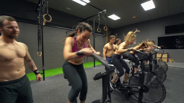 Athletes doing airbike workout in fitness centre