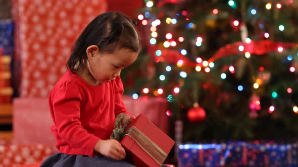 Young girl shaking Christmas gift