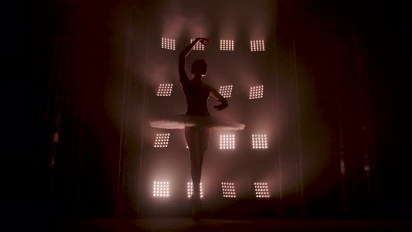 Graceful Silhouette Ballerina Dancing in Black Dress in the Studio in Spotlight on the Stage of the