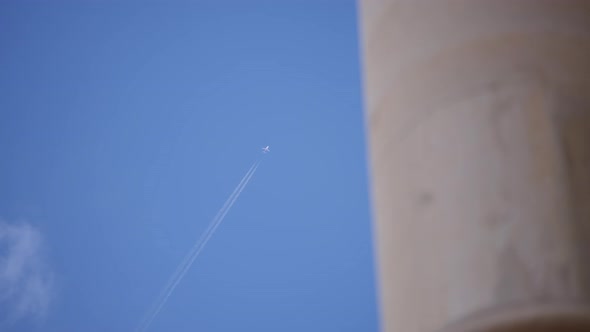 An airplane flying high in the blue sky