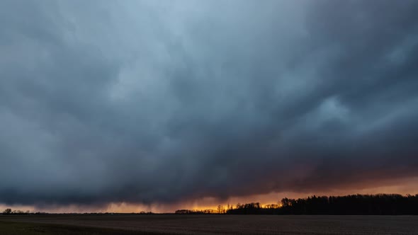 Beautiful stormy clouds moving towards the camera. The sky turning orange due to sunset and raindrop