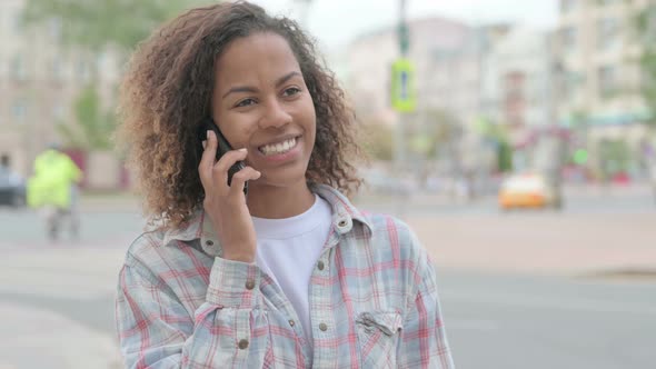 African Woman Talking on Phone While Standing Outdoor