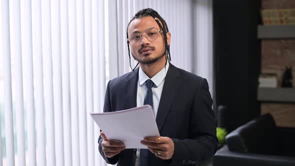 Young black man, extraordinary office employee looks into the camera