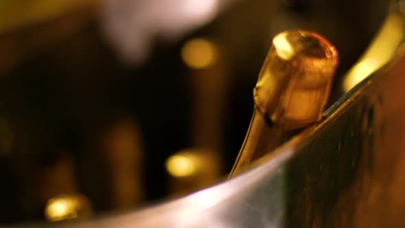 Gold champagne bottles in a metal cooler filled with ice
