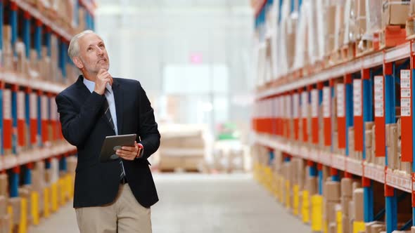 Male warehouse manager using digital tablet