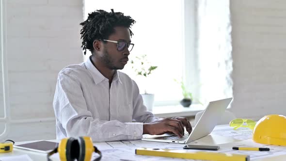 African Engineer Smiling at Camera in Office