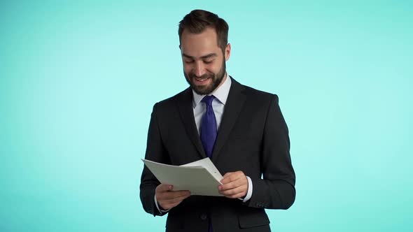 Young handsome man in suit jacket checks documents, utility bills, report. 