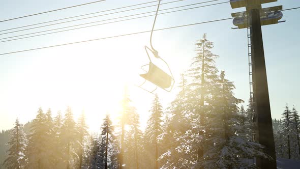 Empty Ski Lift. Chairlift Silhouette on High Mountain Over the Forest at Sunset
