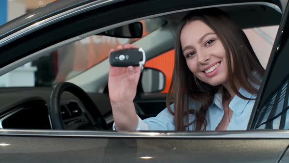 Young Woman Showing Key To New Car