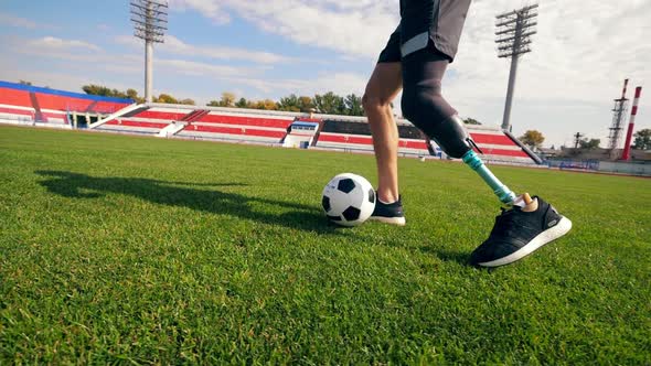 Footballer with a Bionic Leg Is Running with a Ball