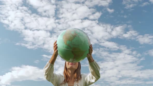 The Concept of Sustainable Ecology and the Global Environment with a Woman Holding a Globe Over Her