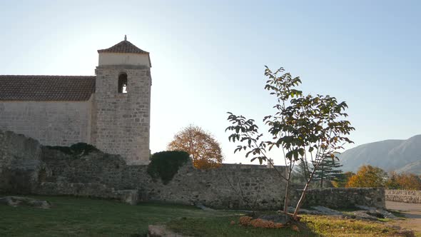 A bell tower close to stone ruins 