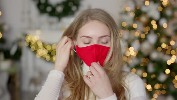 Tired Woman Take Off Protective Face Mask While Standing in Festive Decorated Home for Christmas