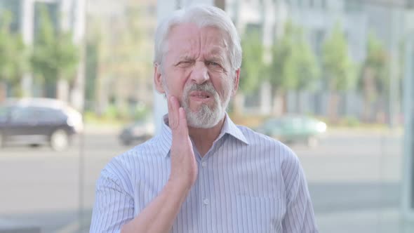 Portrait of Old Man Having Toothache Outdoor