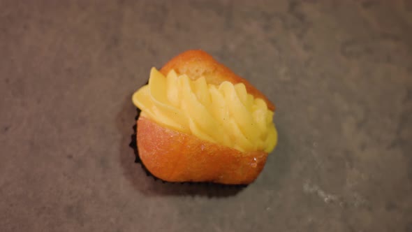 Fresh Cupcake with Custard Lies on Brown Tabletop Macro