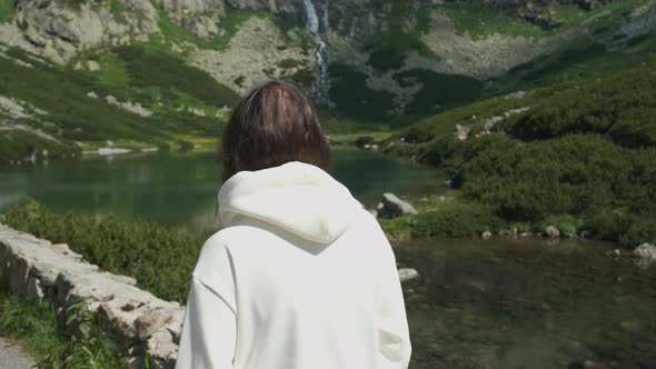 Woman Walking Across Velicke Lake Shore with Amazing View on the Waterfall, Slovakia.