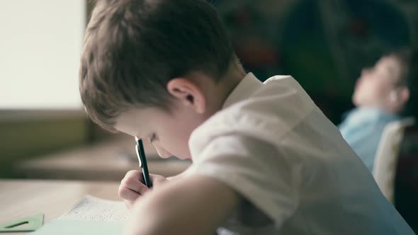 CU Children Do Their Homework One Sits at the Table with Notebooks