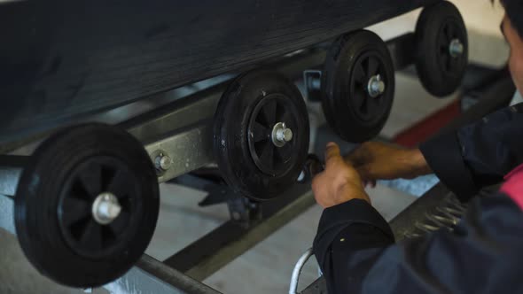 Master Asian Working with Wrench on Truck