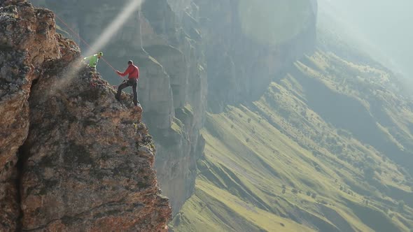 A Group of Climbers Discussing a Plan of Action Standing on the Edge of the Cliff