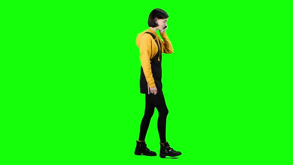 Girl Is Talking on the Phone Walking Down the Street. Green Screen. Side View
