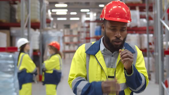 Young African Manager Coughing and Feeling Sick in Warehouse