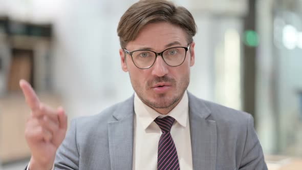 Portrait of Serious Businessman Saying No By Finger Sign