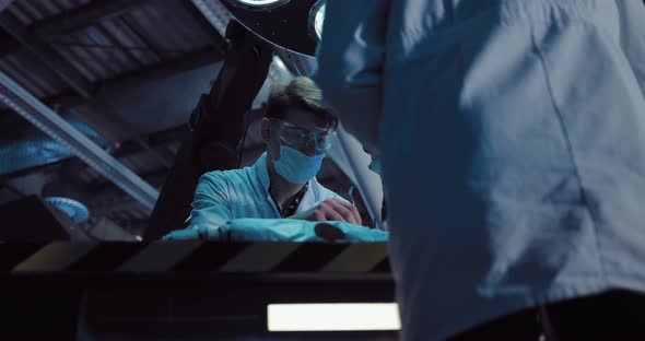 Male Surgeons Perform an Operation in the Laboratory of the Spacecraft