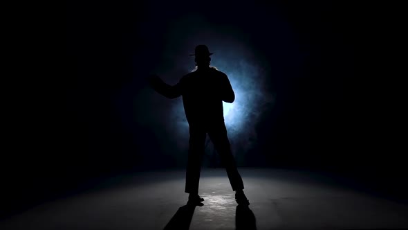 Silhouette of a Young Man Dancer Dancing in Style Michael Jackson on a Blue Background of Smoke