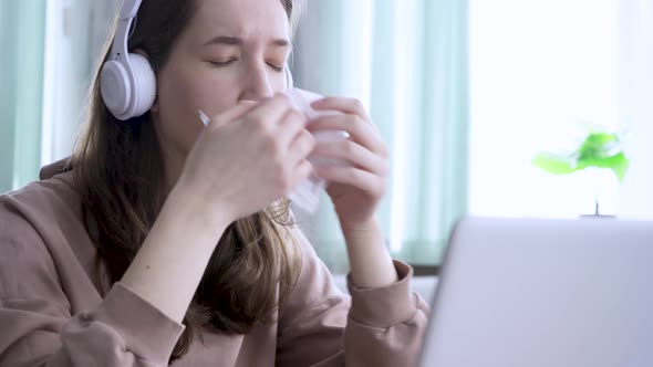 Teenage School Girl with a Flu Blowing Nose Studying at Home