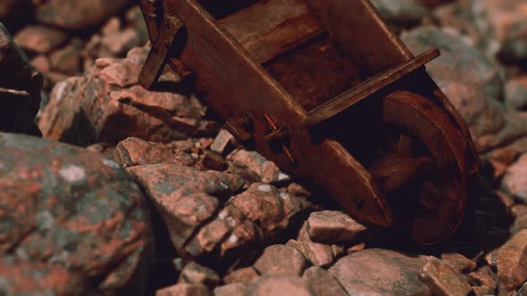 Abandoned Wooden Mine Wheelbarrow on Rocks