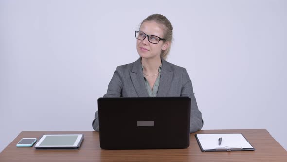 Young Happy Blonde Businesswoman Thinking While Using Laptop at Work