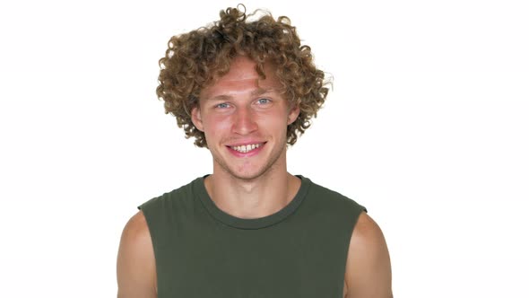 Portrait of American Smiling Curly Man in Green Muscle Shirt Looking on Camera with Smile Winking