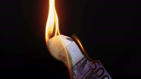 Burning of 500 Euro Banknote on Black Studio Background