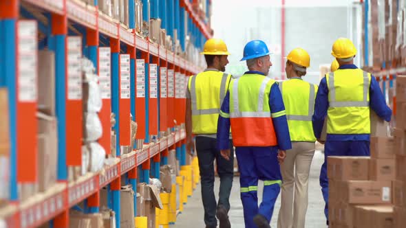 Male and female warehouse worker carrying cardboard boxes