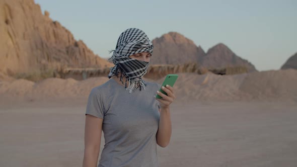 Female Tourist in Checkered Keffiyeh Trying to Find Mobile Network Using Smart Phone Standing in