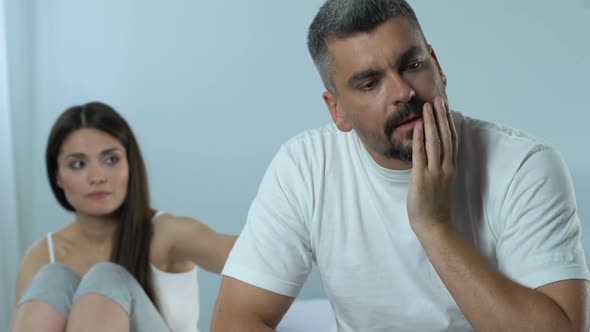 Upset Man and Supportive Wife Sitting in Bedroom, Impotence, Family Crisis