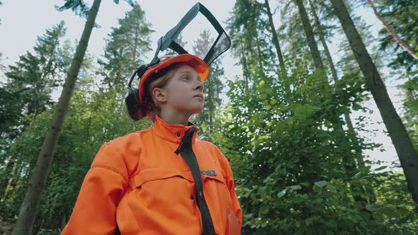 Portrait of a Female Logger Standing in the Forest a Young Specialist Woman in Protective Gear Slow