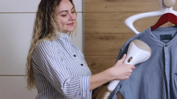 Beautiful Housewife Irons Her Shirt Inside the House with a Steamer