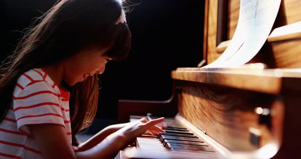 Schoolgirl learning piano in music class 4k
