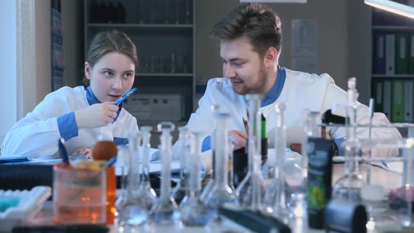 Young Scientists are Talking at Table During Working Day in Pharmaceutical Laboratory Spbas