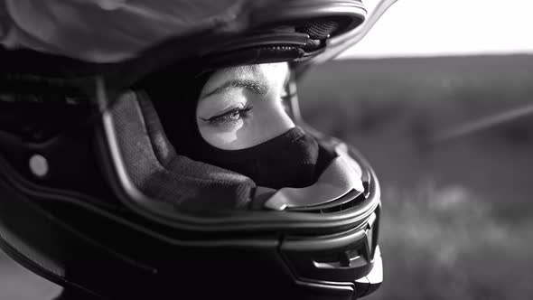 Black and White Portrait of Confident Motorcyclist Woman in Closed Motorcycle Helmet