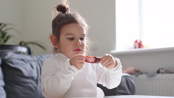 Child Eating Dried Fruit Leather for Snack at Home