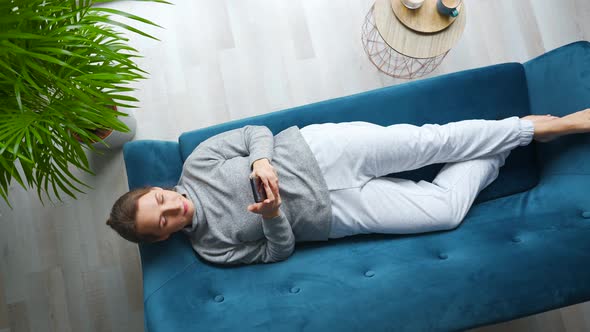 Overhead Shot of Happy Relaxed Woman Holding Smart Phone Using Mobile Apps Watching Funny Video