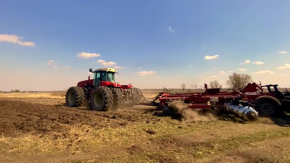 Large tractor preparing field for sowing
