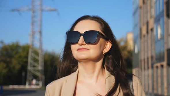 Portrait of Beautiful Lady in Sunglasses Walking at Sidewalk