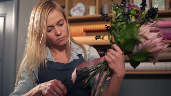 Female Blonde Florist Arranging Modern Bouquet