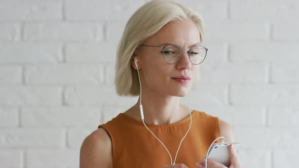 Lady in Earphones Using Smartphone