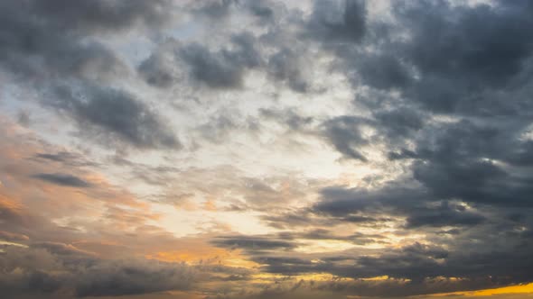 Time lapse footage of fast moving evening clouds on yellow sky at sunset.