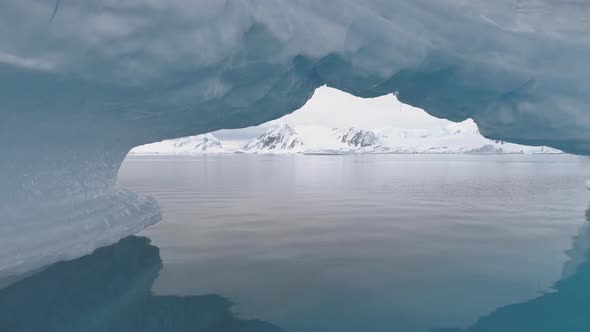 Antarctica Shot Through Iceberg Arch.