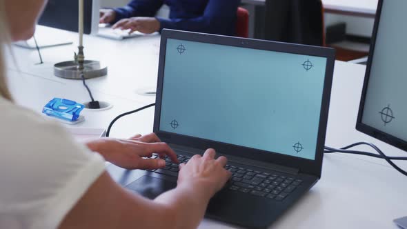 Hands of caucasian businesswoman using laptop at desk in office